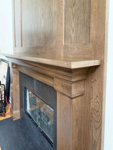 Close-up of a wooden fireplace mantel with detailed craftsmanship.