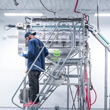 Technician operating industrial equipment in a clean, modern facility.