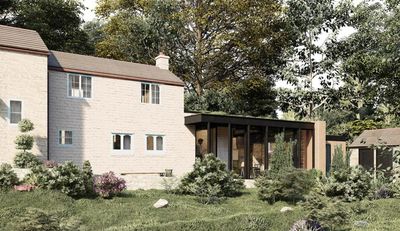 Stone house with modern glass extension surrounded by greenery and trees.