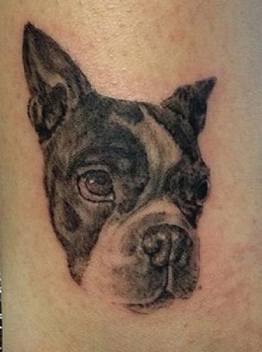 Detailed black and gray dog face tattoo on skin.