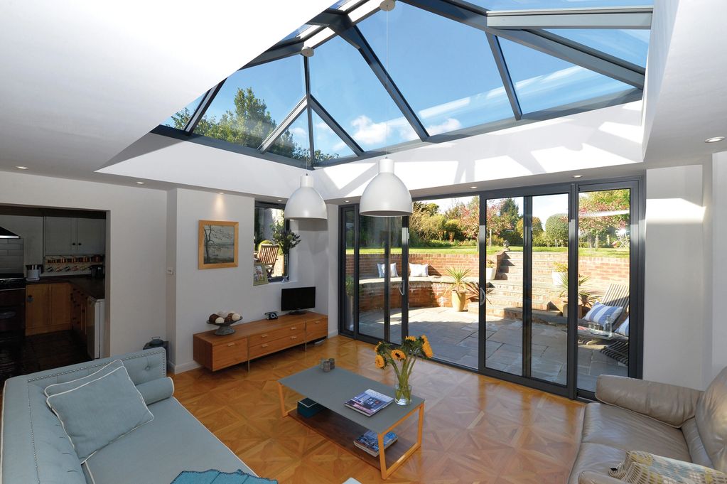 Inside of a house with white painted walls and black aluminium windows, bifold doors and lantern