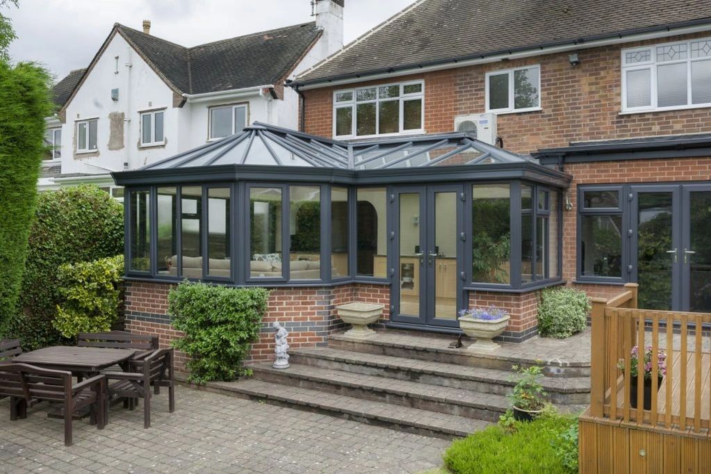 white upvc windows and a grey conservatory with grey upvc indows and doors with grey roof