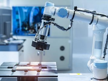 A robotic arm working with a microchip in a lab.