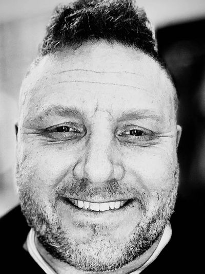 Black and white photo of a white male smiling. 