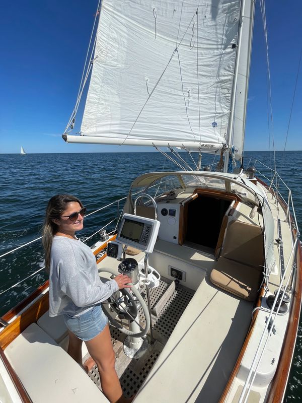Jenna sailing her family sailboat, admiring the beauty of the ocean