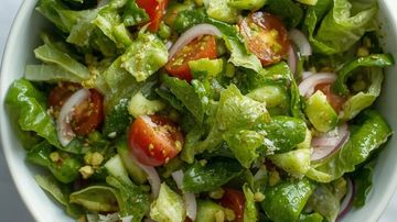 Fresh green salad with lettuce, cherry tomatoes, cucumber, and onions.