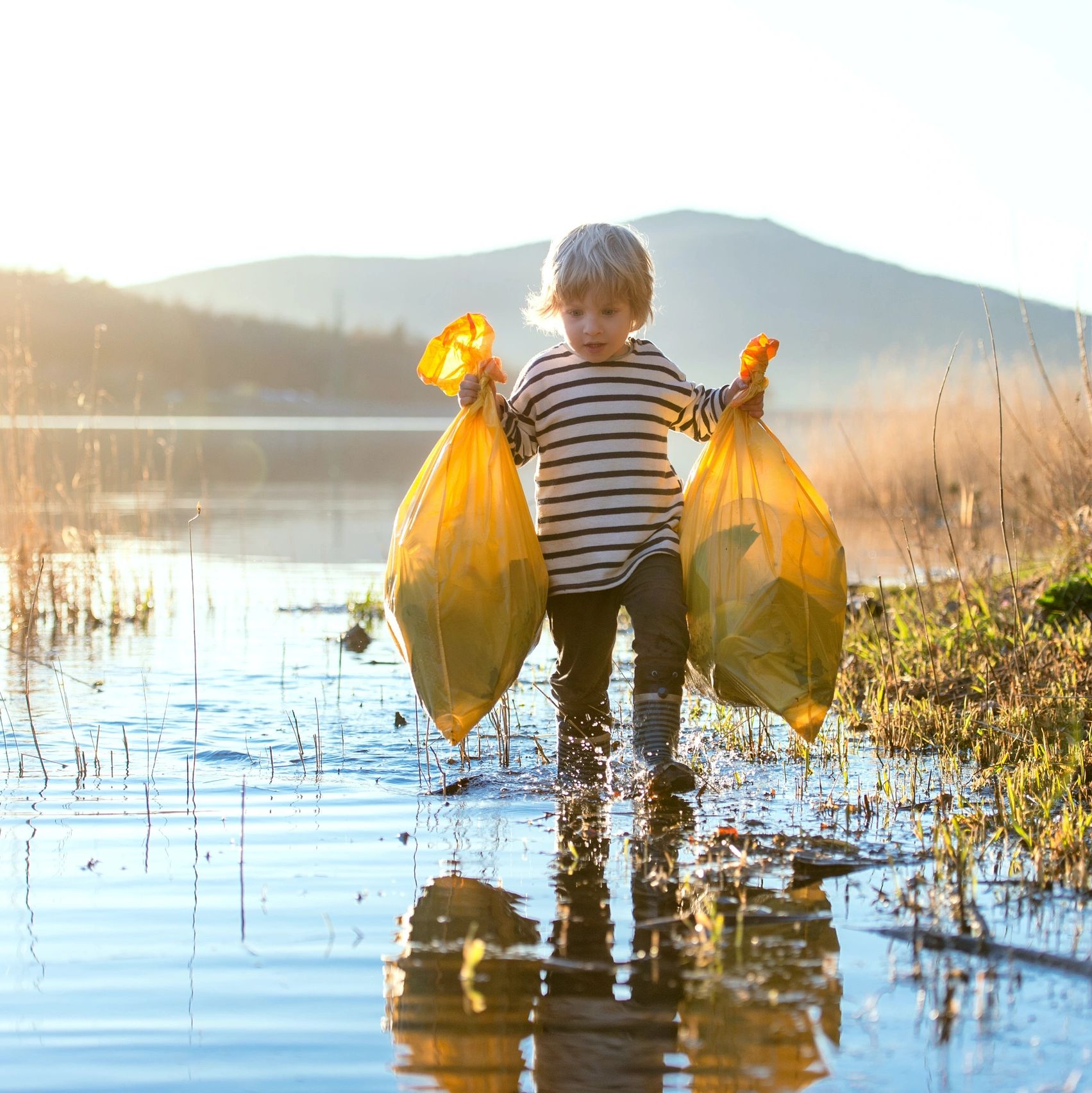 A child carrying garbage. photo credit: Unsplash+ in collaboration with Getty Images