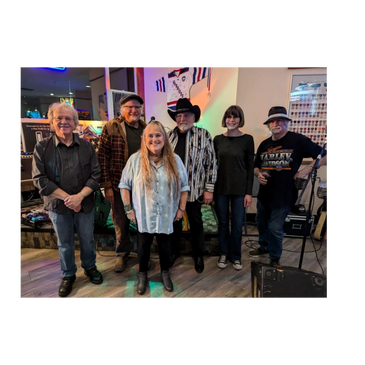 A group of six people posing indoors, some wearing hats and casual clothing.