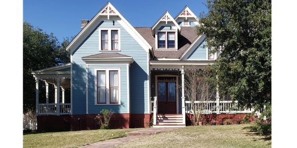 Blue Victorian-style house with white trim and porch.