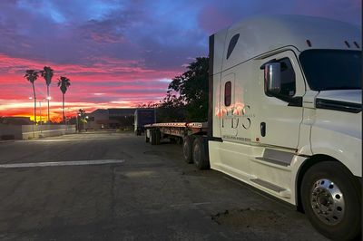 CDL training center truck parked with palm tree and the sunset. Premier trucking school