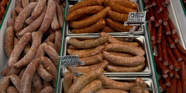 Various types of sausages labeled as Jalapeno Cheddar Polish and Cheddar Polish.