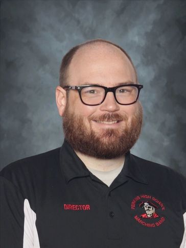 Man with glasses and beard wearing a director shirt.