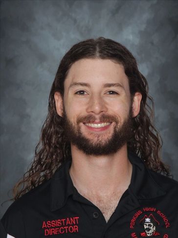 Smiling man with long curly hair and beard.