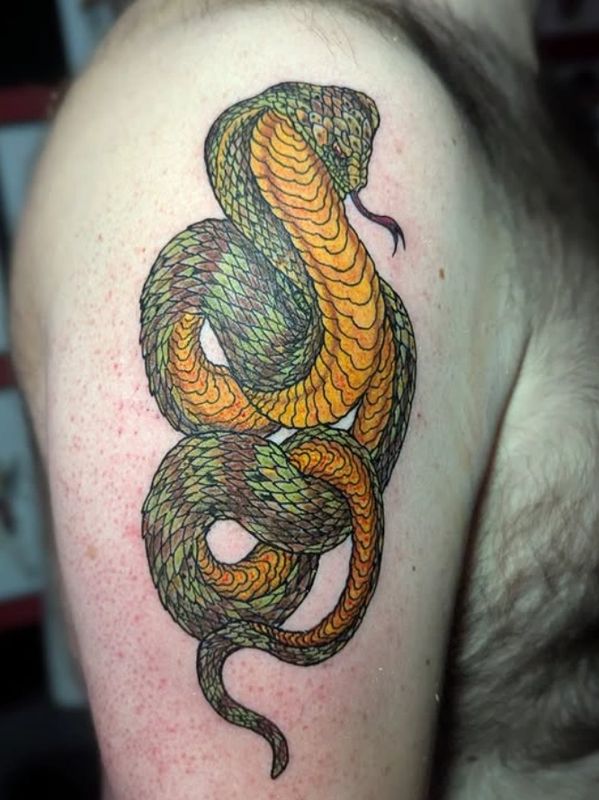 Colorful snake tattoo with intricate green and orange scales on an arm.