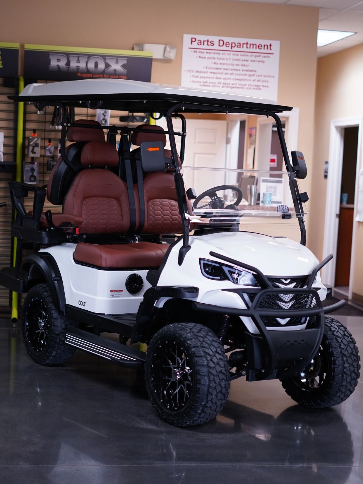 White 4 seat coltgolf cart with windshield