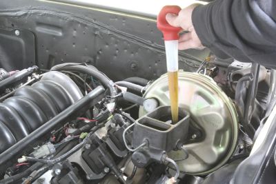 Checking brake fluid level in a car.