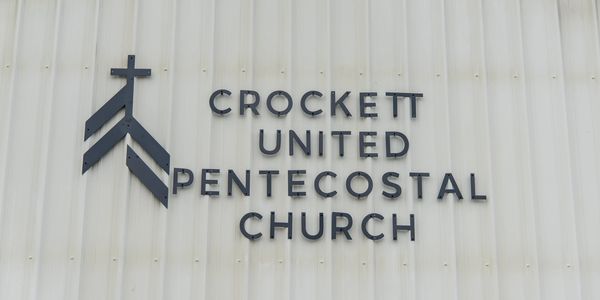Crockett United Pentecostal Church sign on a white wall.