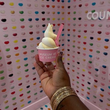 Hand holding ice cream cup in colorful jellybean museum.
