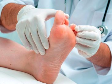 Médico examinando un pie con guantes.