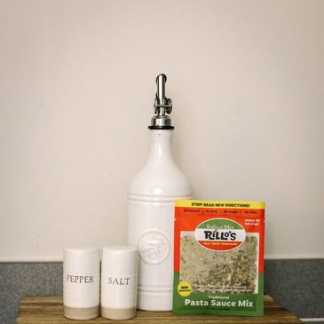 Rillo's Italian Mix on a kitchen counter on a wooden board with salt, pepper, and an olive