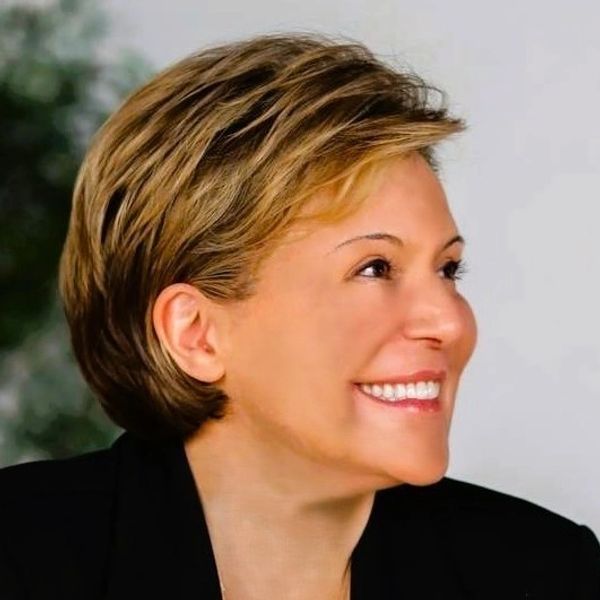 Profile of a smiling woman with short hair.