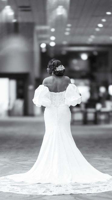 Bride in an elegant white gown with puffed sleeves and intricate back details.
