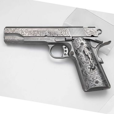 Intricately engraved silver handgun with floral patterns and stars.