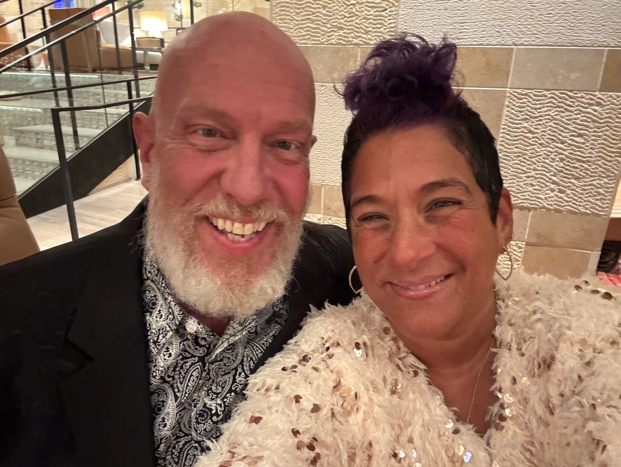Smiling couple taking a close-up selfie indoors.