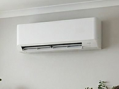 Modern white wall-mounted air conditioner in a room.