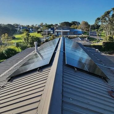 Solar panels installed on a residential rooftop under clear skies.
