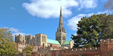 Historic cathedral with a tall spire under a blue sky.