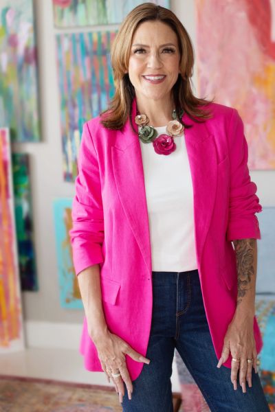 Smiling woman in a pink blazer.