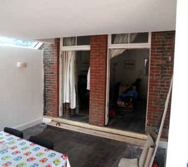 Open brick patio doors with white curtains leading to an indoor room.