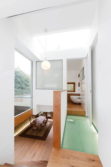 Modern interior with glass floor and dining area below.