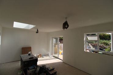 Room under construction with bare walls and tools scattered.