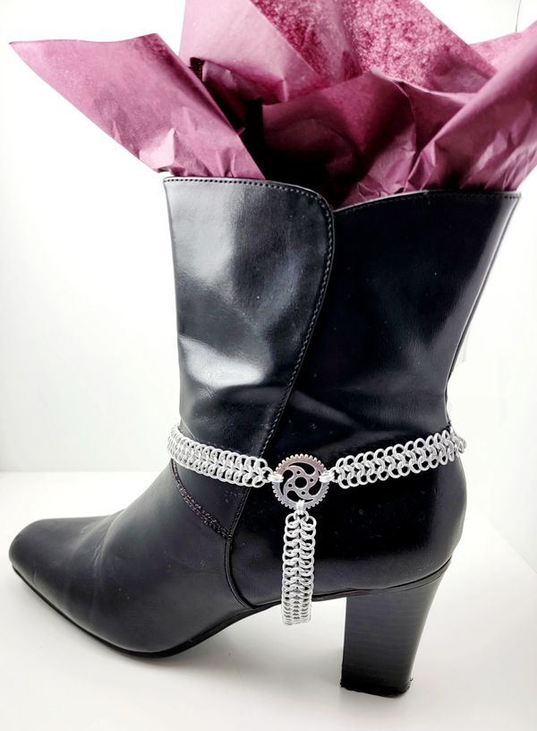 A black boot with a silver chain