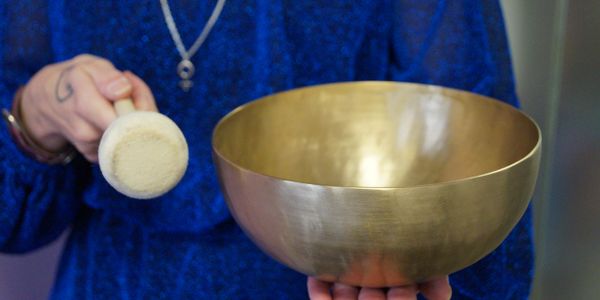 Playing a singing bowl for mindful meditation