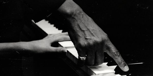 Roger Boykin teaching young hands to play the piano. 