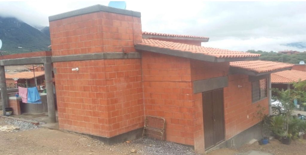 Casa de ladrillo con techo de teja en zona rural.