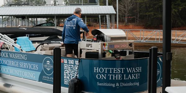 A man operates a boat offering lake dock cleaning services.