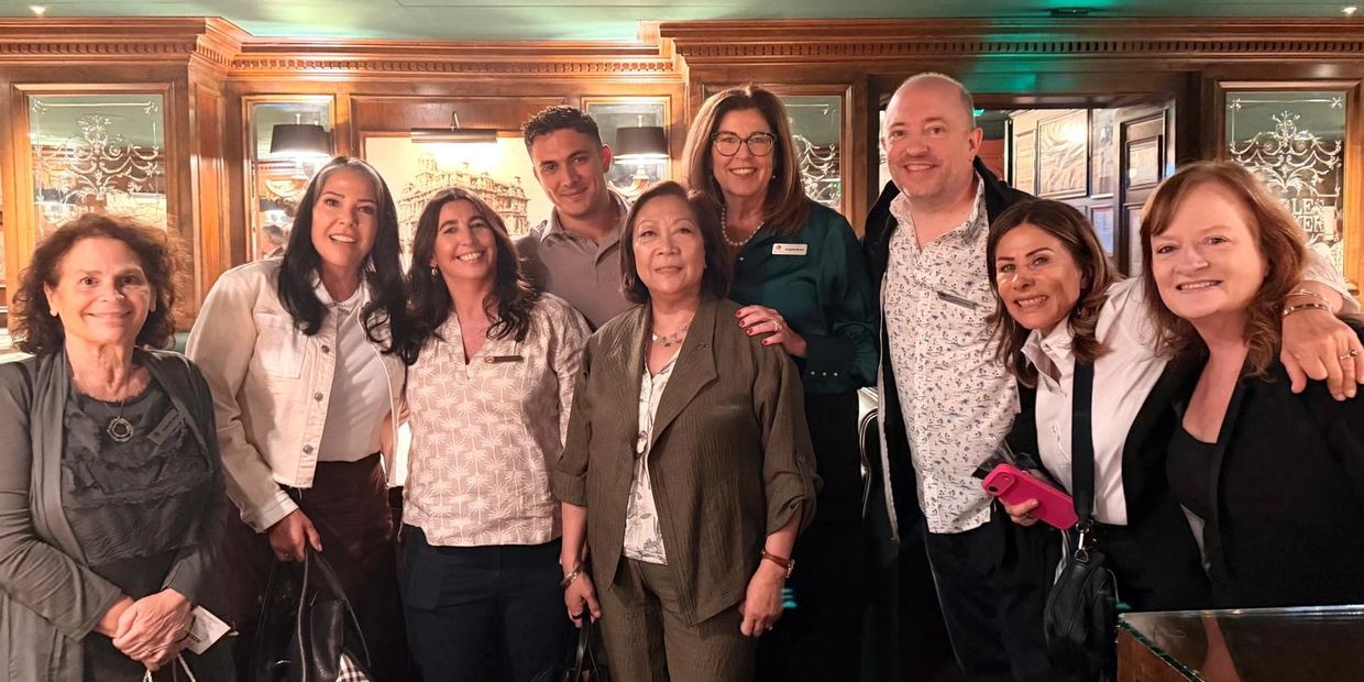 Group photo of nine smiling people indoors.