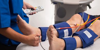 A patient undergoing a vascular or blood pressure test with sensors attached to legs.