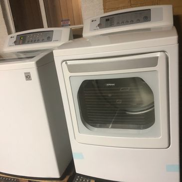 A white washing machine and dryer set standing side by side indoors.