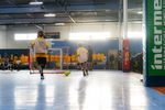 Indoor soccer game with players in yellow jerseys actively playing.