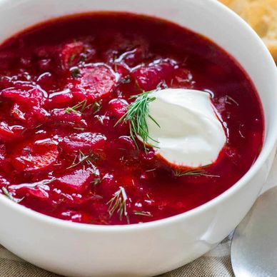 Bowl of bright red Borscht with dollop of sour cream