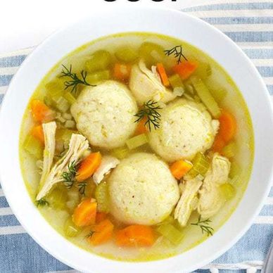 Bowl of chicken soup with chicken,  matzo balls, and vegetables.
