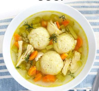 Large bowl of chicken soup with three matzo balls