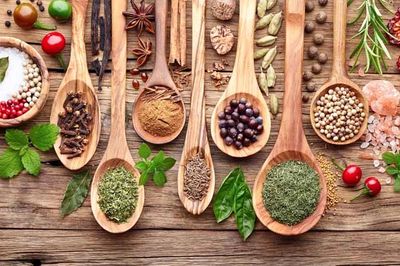 A display of wooden spoons each with different spices