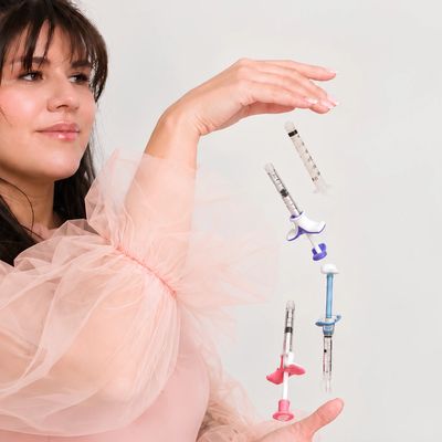 Woman levitating floating syringes with soft pink fabric sleeve.