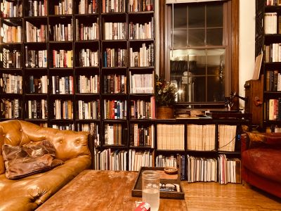 Cozy library corner with leather sofas and a window.